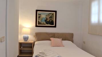 1 dormitorio y tabla de planchar con plancha