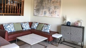A modern living room with a brown leather sectional sofa, a white marble coffee table, and a black and white patterned cabinet. - Villa Rosa Casa Begur (Begur)