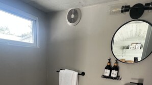 Une petite salle de bain comprenant des toilettes, un lavabo et un miroir.