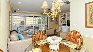 A dining area with a round table, chairs, and a chandelier. - Direct beach access! Summer and fall dates still available, call today! (Bradenton Beach)