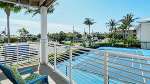 A poolside area with a covered deck, lounge chairs, and a view of a swimming pool. - Direct beach access! Summer and fall dates still available, call today! (Bradenton Beach)