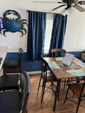 A dining area with a wooden table, chairs, and a ceiling fan.