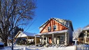 Una casa a due piani con un portico e un vialetto coperto, circondata dalla neve.