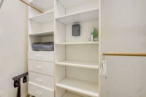 Een kast met open planken, een kledingroede en een opbergunit.