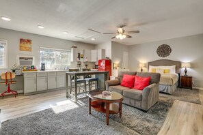 Una sala moderna con sofá, una mesa de centro y un comedor con cocina al fondo.
