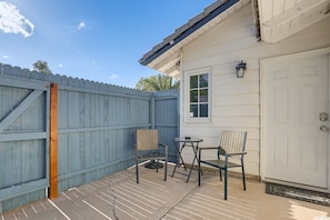 A patio with a table and two chairs, a blue fence, and a white door. - Experience Vegas in Style – Chic Private Suite Near the Strip (Las Vegas)
