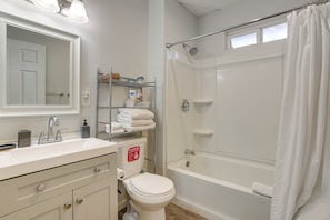 A bathroom with a white sink, mirror, toilet, and bathtub. - Experience Vegas in Style – Chic Private Suite Near the Strip (Las Vegas)