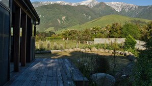 Una terraza de madera con vista a montañas nevadas.