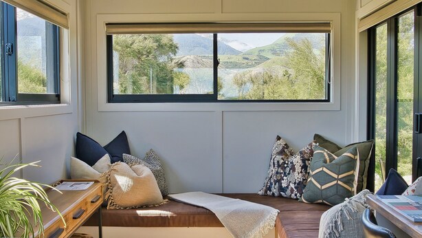Cómoda zona de estar con vista a un paisaje montañoso a través de amplias ventanas.