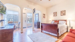 A spacious bedroom with a large bed, a desk, and a chair, connected to a dining area with a table and chairs. - Rustic Studio walking distance to Downtown (Reno)