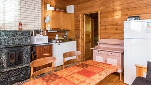 Una cocina compacta con armarios de madera, un microondas, una estufa y un refrigerador.