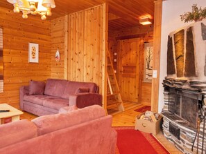 A wooden interior with a fireplace, a sofa, and a ladder. - Susitupa 6 by Interhome (Salla)
