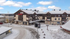 A multi-story building with a ski lift, a SUBWAY, and a Ruka Village sign. - Ruka ski chalets 64, 1302 by Interhome (Kuusamo)
