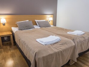 A double bed with two pillows, a nightstand, and a lamp. - Ruka ski chalets 64, 1302 by Interhome (Kuusamo)