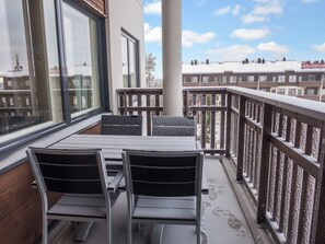 A balcony with a table and chairs, a railing, and a view of buildings in the background. - Ruka ski chalets 64, 1302 by Interhome (Kuusamo)