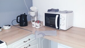 A kitchen with a coffee maker, a microwave, and a kettle on a wooden countertop. - Coeur de ville, T2, pedestrian street, Digne les Bains  (Digne-les-Bains)