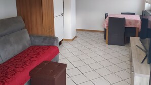 Un espacio habitable compacto con un sofá, una mesita y un armario.