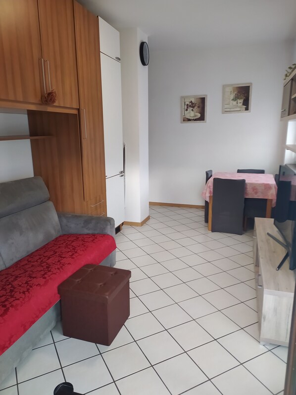 A compact living space with a sofa, a small table, and a cabinet.