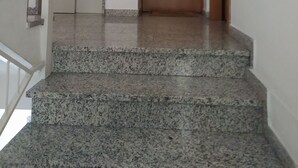 Una escalera de piedra con escalones de granito que lleva a una puerta cerrada.
