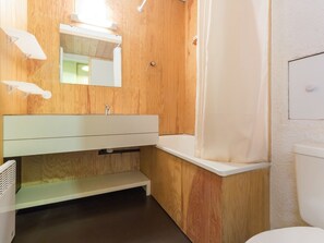 A modern bathroom with wooden paneling, a white sink, and a shower curtain. - Studio in Plagne Villages, slope access, balcony (Plagne Villages)