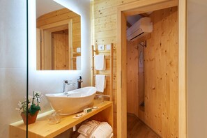 Un baño de madera con un lavamanos grande, un espejo y un perchero para toallas.