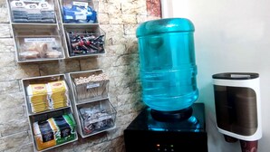 A water dispenser, a coffee machine, and various tea and coffee pods on a counter. - Ginto Residence (Coron)