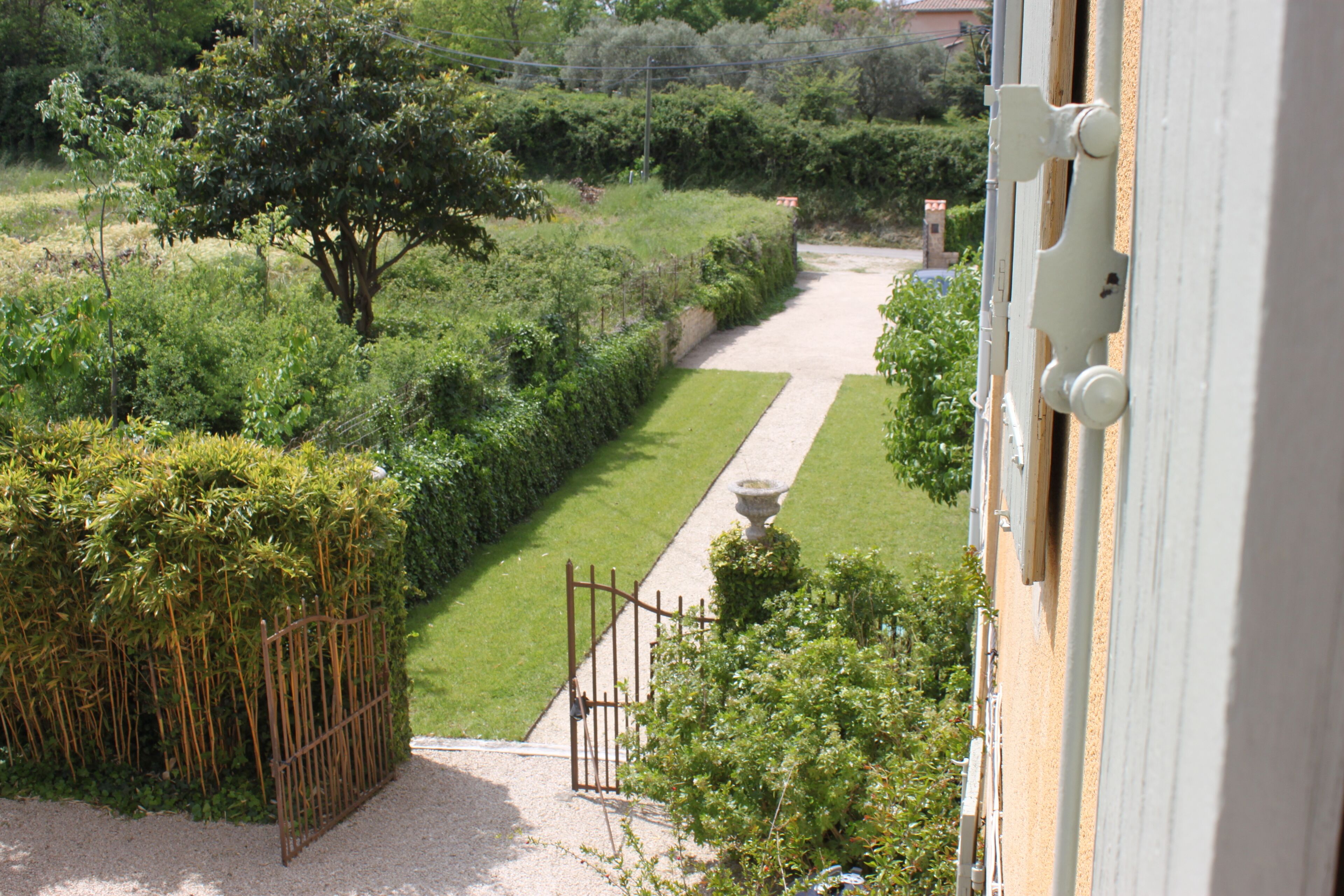 A garden pathway leading to a building with a white exterior.