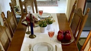 A dining table set with plates, cutlery, and a glass of wine.