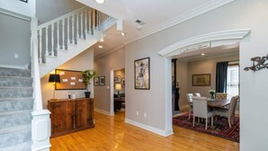 A spacious living area with hardwood flooring, a staircase, a dining area with a table and chairs, and a kitchen in the background. - This house is a 3 bedroom(s), 2.5 bathrooms, located in Lexington, KY. (Lexington)