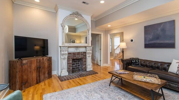 A living room with a fireplace, a television, a leather sofa, and a coffee table. - This house is a 3 bedroom(s), 2.5 bathrooms, located in Lexington, KY. (Lexington)