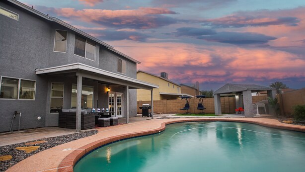 A residential backyard with a swimming pool, a covered patio, and a barbecue area. - 4BR w pool, dog-friendly, near Westgate (Phoenix)