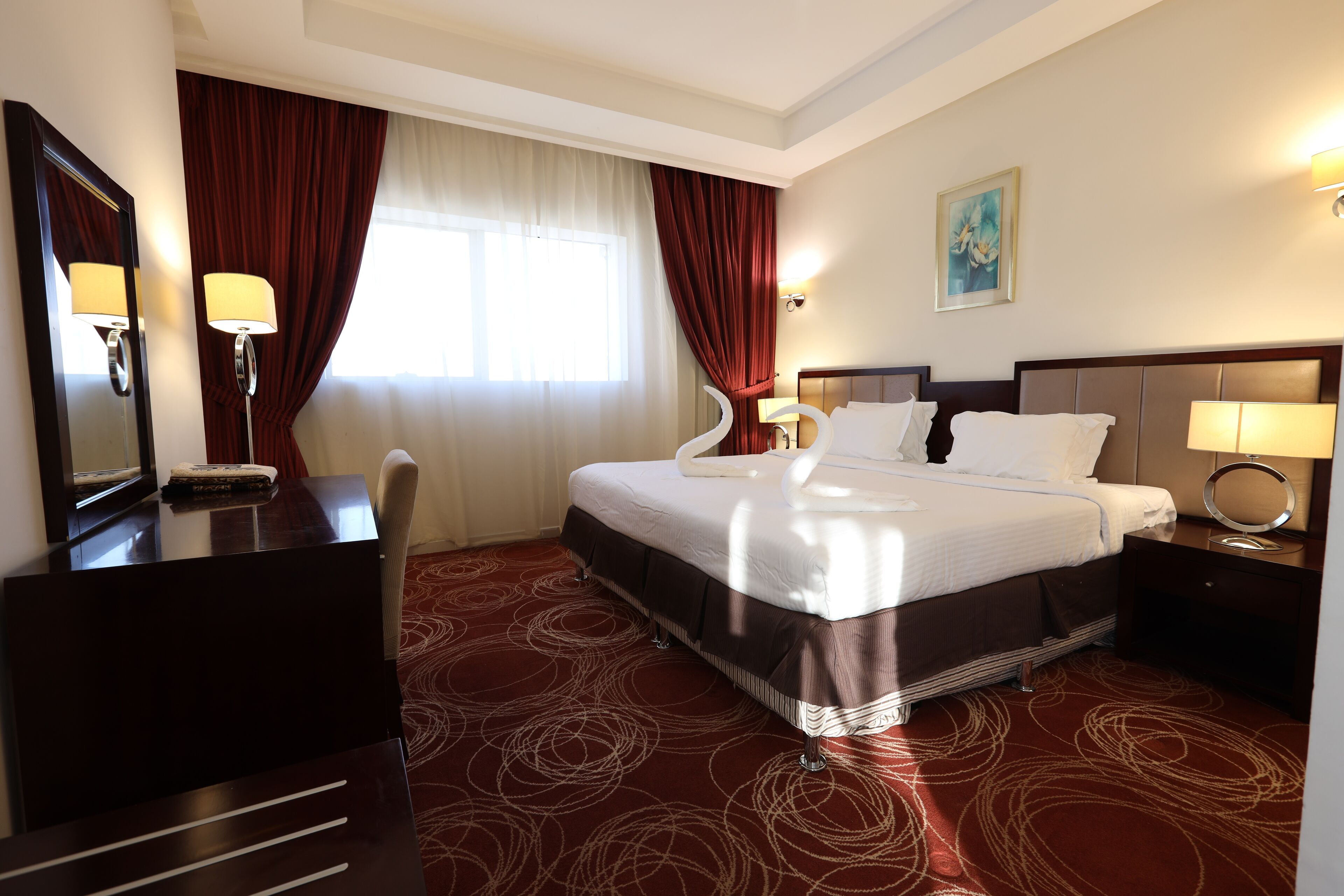 Une chambre d’hôtel avec un grand lit, un bureau et une chaise.