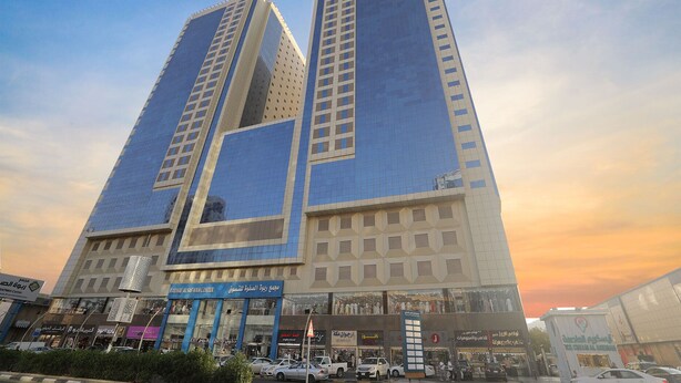A modern building with two prominent towers, featuring a mix of glass and concrete facades, and a ground-level entrance with signage. - Al Rayyan Makiya Towers Hotel (Makkah)