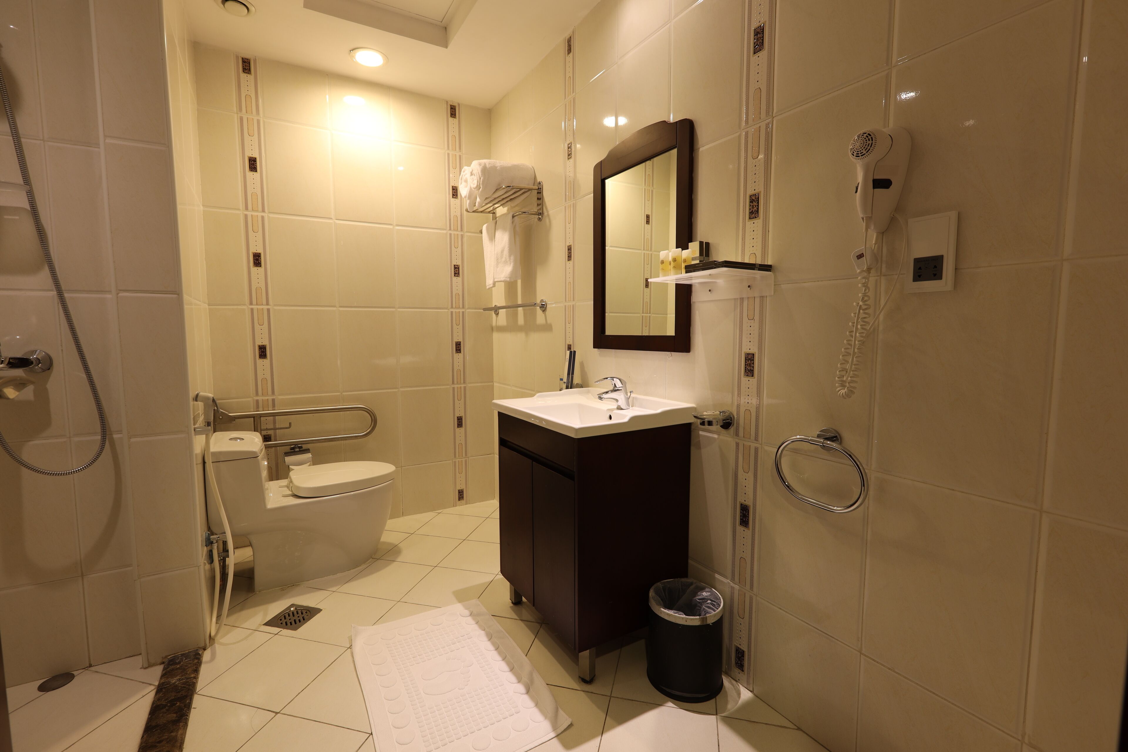 A modern bathroom with a toilet, sink, mirror, and shower.