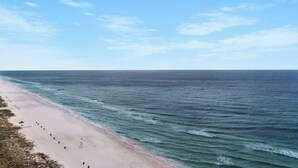 A beach with a clear sky, calm sea, and a sandy shore. - Incredible Gulf Front 1BD, Pools, Hot Tubs, and Free Attraction Tickets! (Panama City Beach)