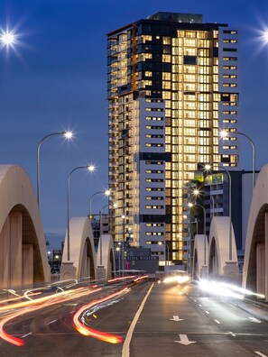 Ein modernes, hoch aufragendes Hotel mit mehreren Etagen, großen Fenstern und einer gut beleuchteten Fassade.