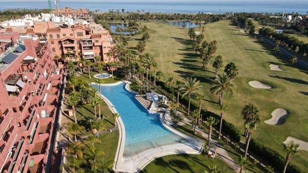 A resort with a large swimming pool, golf course, and beachfront view. - Cozy and quiet apartment (Motril)