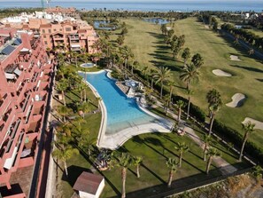 A resort with a large swimming pool, golf course, and beachfront view. - Comfortable and quiet apartment (Motril)