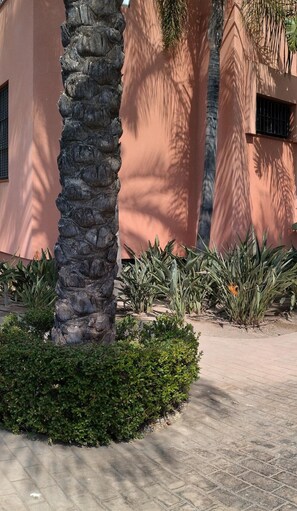 Stroll through a beautifully maintained garden with a tranquil atmosphere and a striking stone pillar.