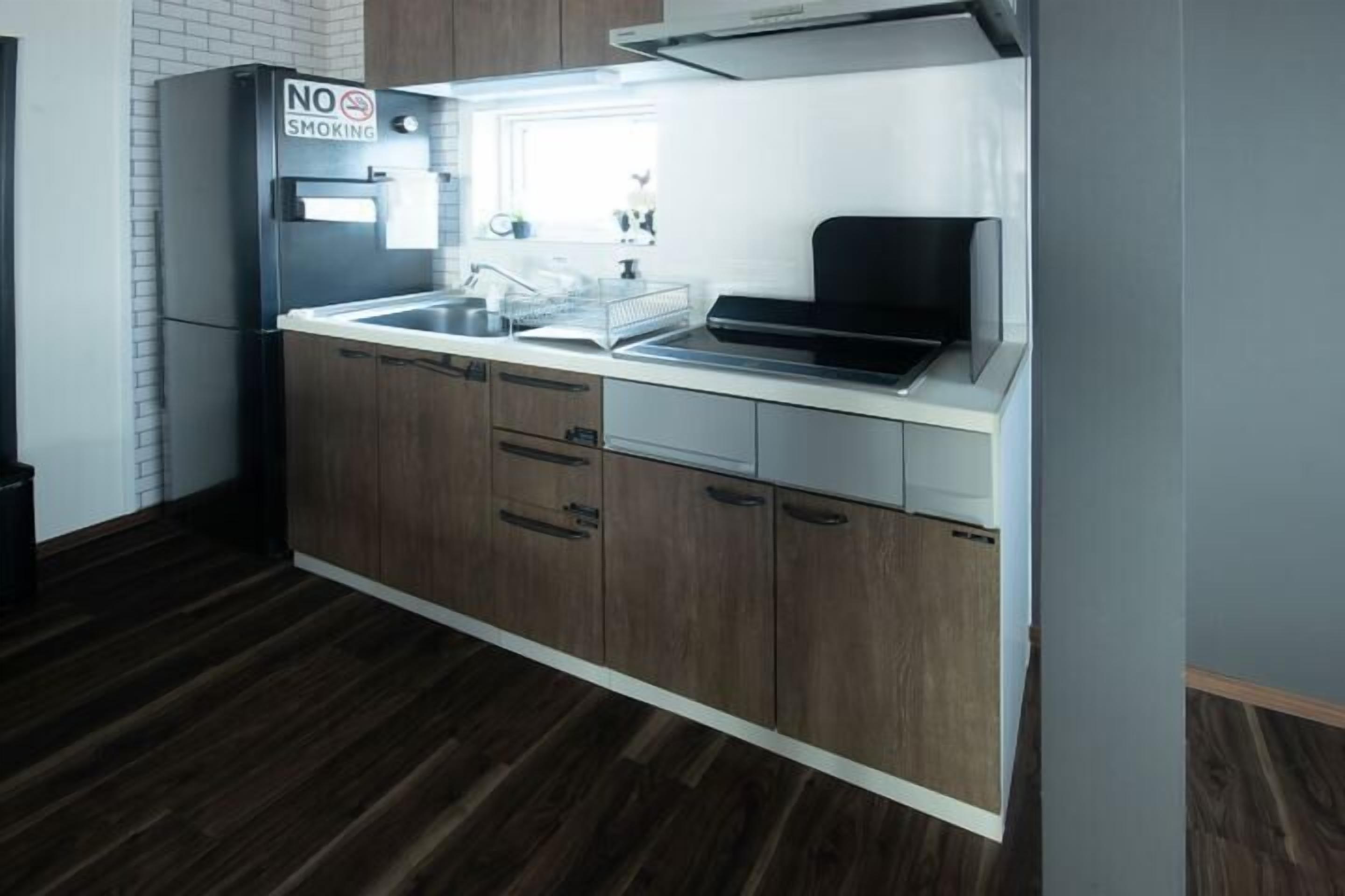 A modern kitchen with a stainless steel refrigerator, a microwave, and a sink.