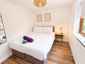 A bedroom with a bed, bedside table, lamp, and two framed pictures on the wall. - Middle Ashbrook  - up to 6 bed - 3.5 bathrooms (Didcot)