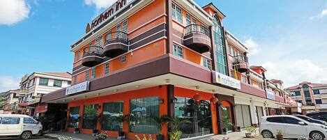 Un edificio de varios pisos con un llamativo letrero que dice 'Northern Inn', con balcones y ventanas grandes.