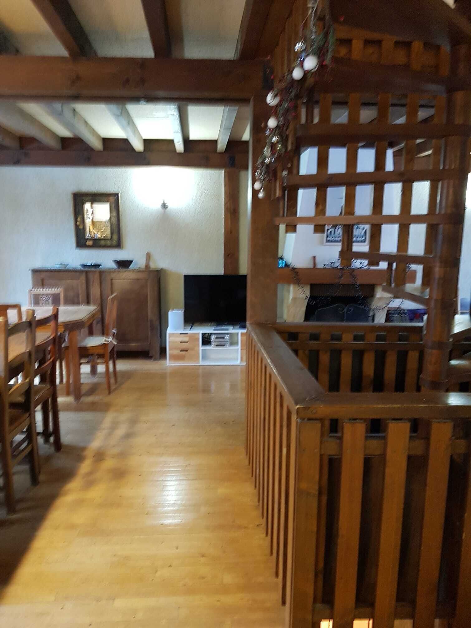 Ein Wohnzimmer mit Holzboden, einem Fernseher, Holzmöbeln und einer dekorativen Holzwand.