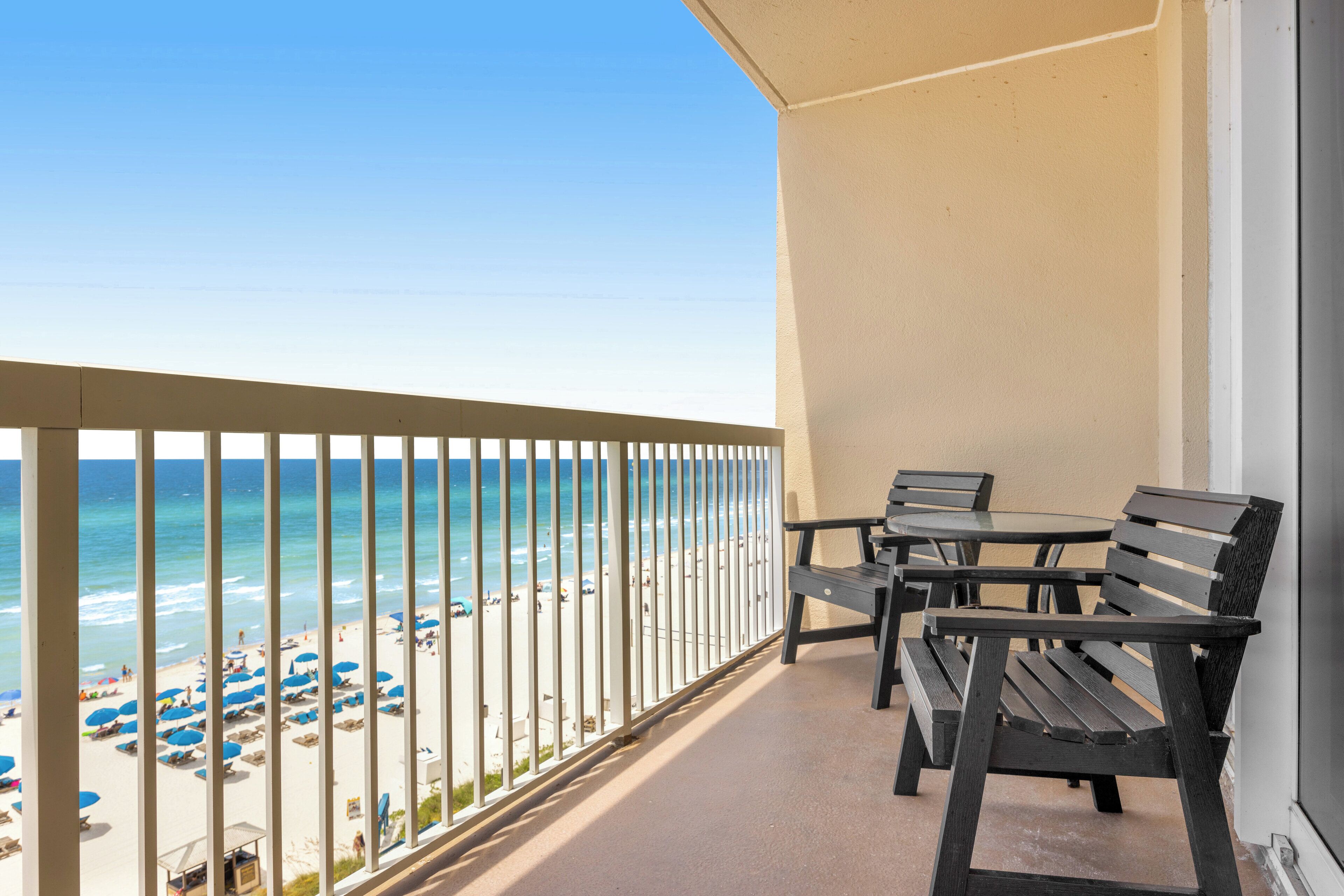 A balcony with a view of the beach and ocean.