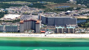 Eine Luftaufnahme einer Küstenstadt mit einem großen Hotelkomplex, einem Strand und umliegenden Gebäuden.