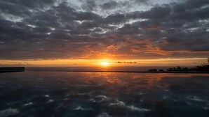 A sunset over a body of water with clouds reflecting on the surface. - Villa Maho with breathtaking views (Petite Île)