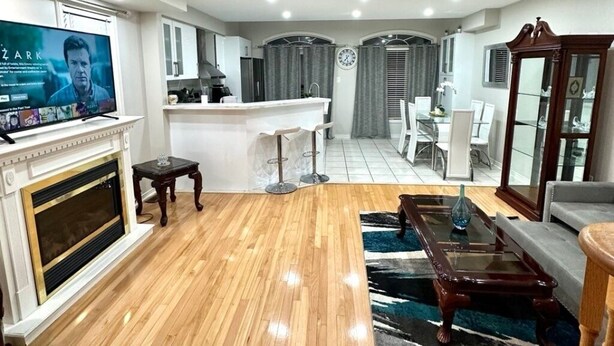 Una sala de estar moderna con chimenea, televisor, comedor y cocina.