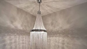 Un candelabro con diseño de cristal colgando del techo con textura.