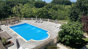 A rectangular swimming pool with a tiled deck, surrounded by a white railing. - Beautiful old cottage, with a  rear terrace giving stunning panoramic views.  (Lacépède)