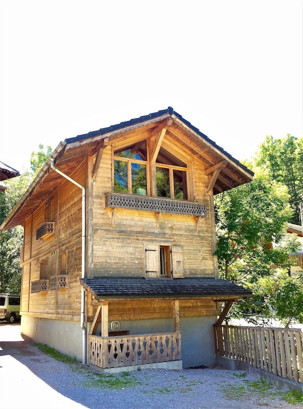 Ein Holzhaus mit Balkon, Fenster und Tür.